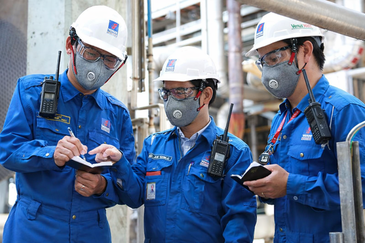 Industrial workers reviewing notes together
